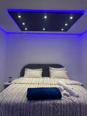 a bedroom with a bed with a blue light on it at Checkmate in Tešanj