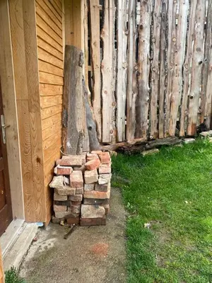 a stack of logs next to a fence at Farma 2 in Cazin