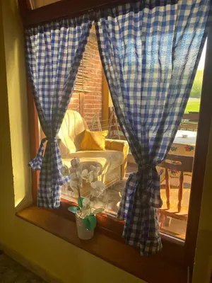 a window with curtains and a bed in a room at Farma 2 in Cazin