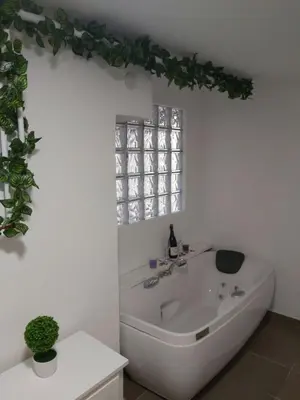 a white bathroom with a tub and a window at Apartman MIA in Travnik
