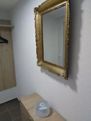 a mirror on a wall next to a table at Apartman MIA in Travnik