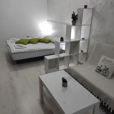 a white room with a bed and a table at Apartman Jevrejska Banja Luka in Banja Luka