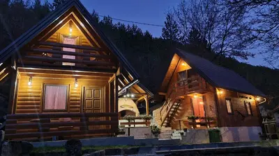 a log cabin with lights on the side of it at Planinske kolibe Šipovo in Šipovo