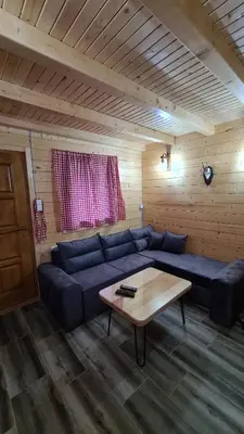 a living room with a blue couch and a coffee table at Planinske kolibe Šipovo in Šipovo