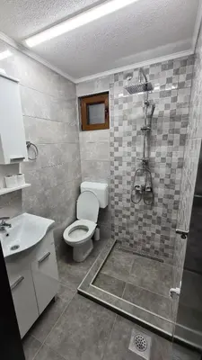 a bathroom with a shower and a toilet and a sink at Planinske kolibe Šipovo in Šipovo