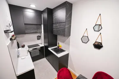 a small kitchen with black and white cabinets at Apartman City Charm in Banja Luka