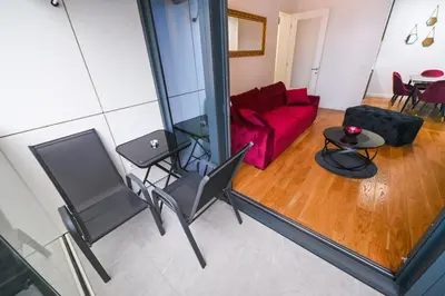 a living room with a red couch and a table at Apartman City Charm in Banja Luka