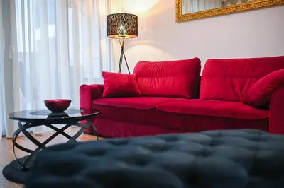 a living room with a red couch and a table at Apartman City Charm in Banja Luka