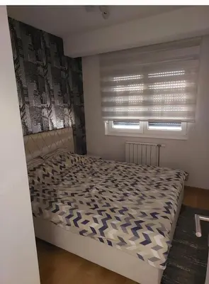 a small bedroom with a bed with a window at Apartman Venecija De Lux in Banja Luka
