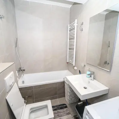 a bathroom with a sink and a tub and a toilet at Apartman Venecija De Lux in Banja Luka