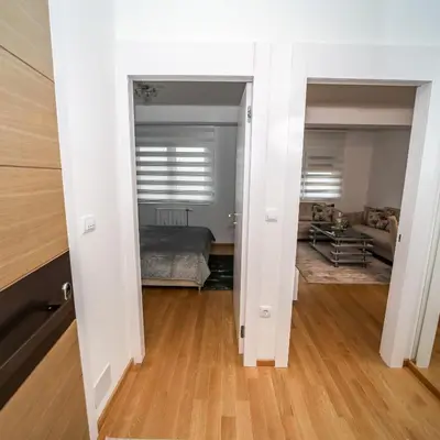 a hallway with a bedroom and a bed in a room at Apartman Venecija De Lux in Banja Luka