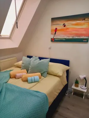 a bedroom with a bed with pillows and a painting at Ena Apartment in Tuzla