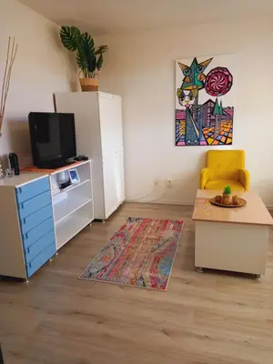 a living room with a refrigerator and a table at Ena Apartment in Tuzla