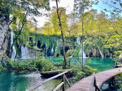a wooden bridge over a river with a waterfall at Villa TeslaS in Velika Kladuša