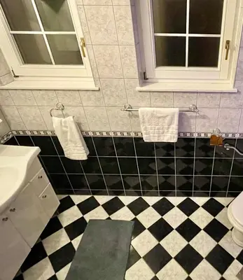 a bathroom with a black and white checkered floor at Villa TeslaS in Velika Kladuša