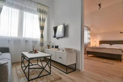 a living room with a bed and a table at Apartman UMA in Bihać