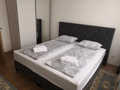 a bed with a black headboard and two pillows on it at Apartman Deni in Travnik