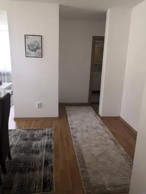 a living room with white walls and a rug at Apartman Deni in Travnik