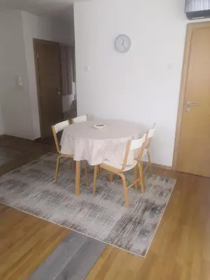 a dining room table and chairs with a white tablecloth at Apartman Deni in Travnik