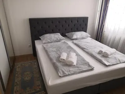 a bed with two blankets and two pillows on it at Apartman Deni in Travnik