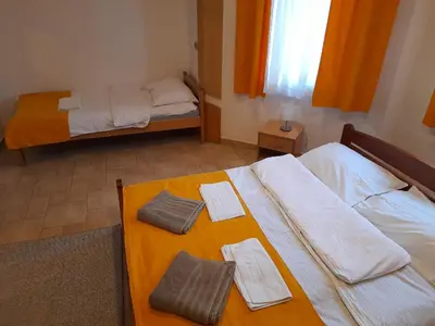 a room with two beds with towels on a table at Domaćinska Kuća Banja Luka in Banja Luka