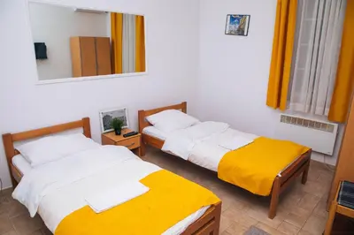 a room with two beds and a mirror at Domaćinska Kuća Banja Luka in Banja Luka