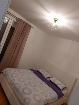a bedroom with a bed with a light and a window at Stan na dan Banja luka in Banja Luka