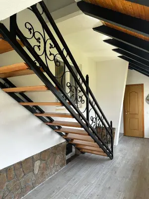 a staircase in a house with black railings at Apartman OGNJIŠTE in Kupres