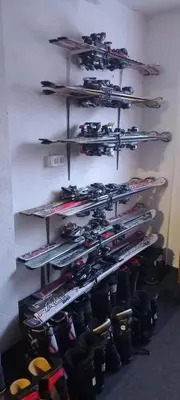 a bunch of skis on a rack on a wall at Apartman OGNJIŠTE in Kupres