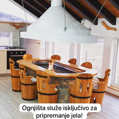 a kitchen with a table with chairs around it at Apartman OGNJIŠTE in Kupres