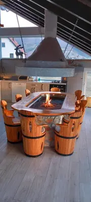a kitchen with a table with a fire in it at Apartman OGNJIŠTE in Kupres
