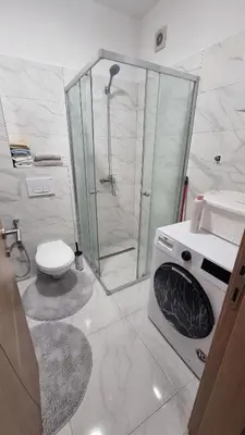 a white bathroom with a shower and a toilet at Visoko Prime Residence in Visoko