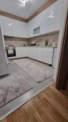 a kitchen with white cabinets and a rug on the floor at Visoko Prime Residence in Visoko