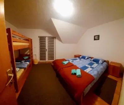 a bedroom with two beds and a bunk bed at Guesthouse Kusić in Kupres