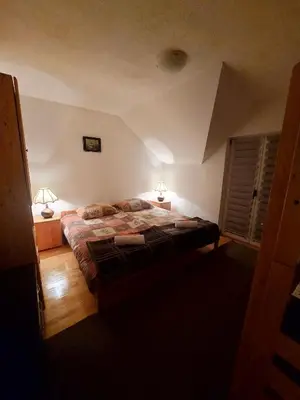 a bedroom with a large bed and two lamps at Guesthouse Kusić in Kupres