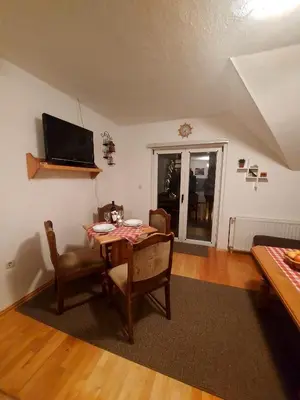 a dining room with a table and chairs and a television at Guesthouse Kusić in Kupres