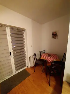a dining room with a table and chairs and a window at Guesthouse Kusić in Kupres