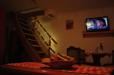 a bowl of fruit on a table with a television in a room at Guesthouse Kusić in Kupres