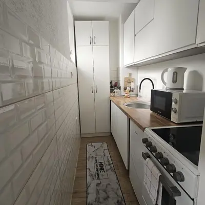 a kitchen with white cabinets and a stove top oven at FRIENDLY HOME in Tuzla