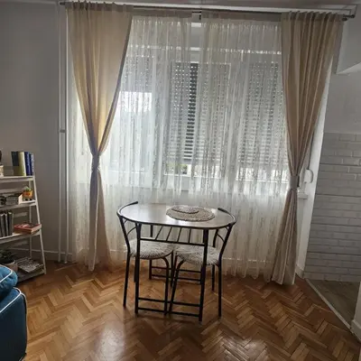 a table and chairs in a room with a window at FRIENDLY HOME in Tuzla