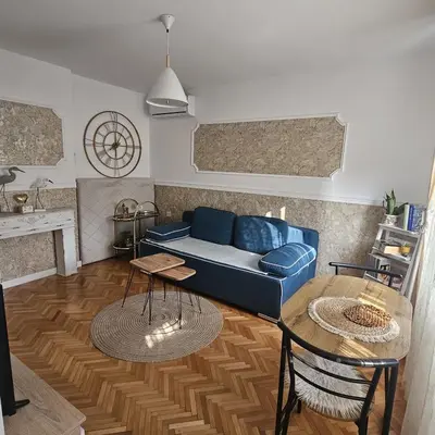 a living room with a blue couch and a table at FRIENDLY HOME in Tuzla