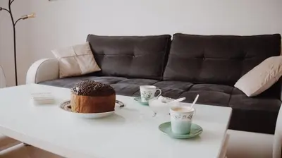a table with a cake and two cups of coffee at Apartman Miškec in Kupres