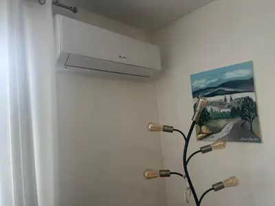 a bathroom with a ceiling fan and a painting at Apartman Miškec in Kupres