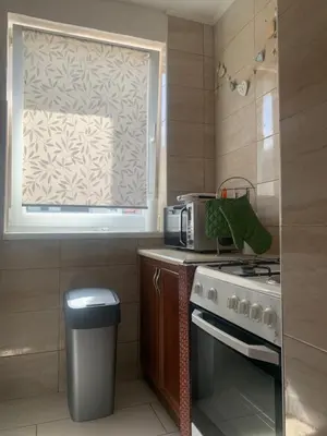 a kitchen with a stove and a window at Apartman Miškec in Kupres