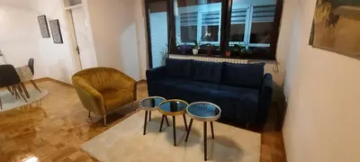 a living room with a blue couch and a chair at Apartman B&D in Tuzla