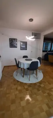 a dining room table and chairs in a room at Apartman B&D in Tuzla