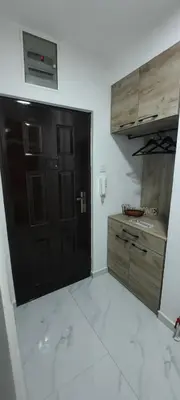 a kitchen with a black door and a white floor at Apartman B&D in Tuzla
