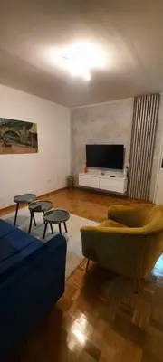 a living room with a couch and a tv at Apartman B&D in Tuzla