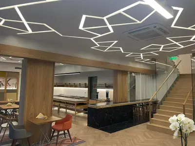 a lobby with a staircase with chairs and tables at Lipa Hotel in Travnik