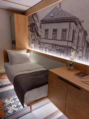 a bedroom with a bed and a desk with a drawing on the wall at Lipa Hotel in Travnik